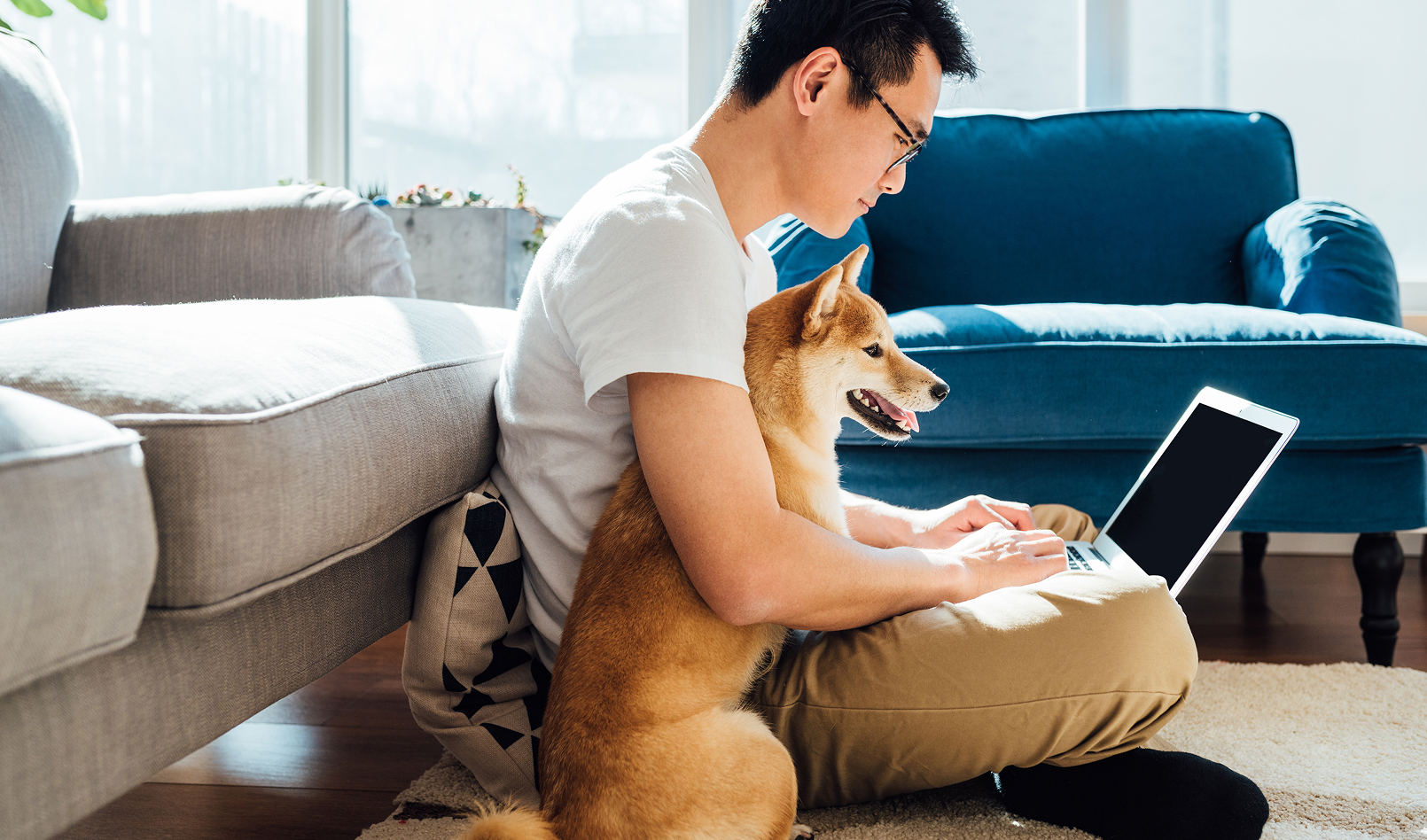 A man and his dog sitting at home and banking online