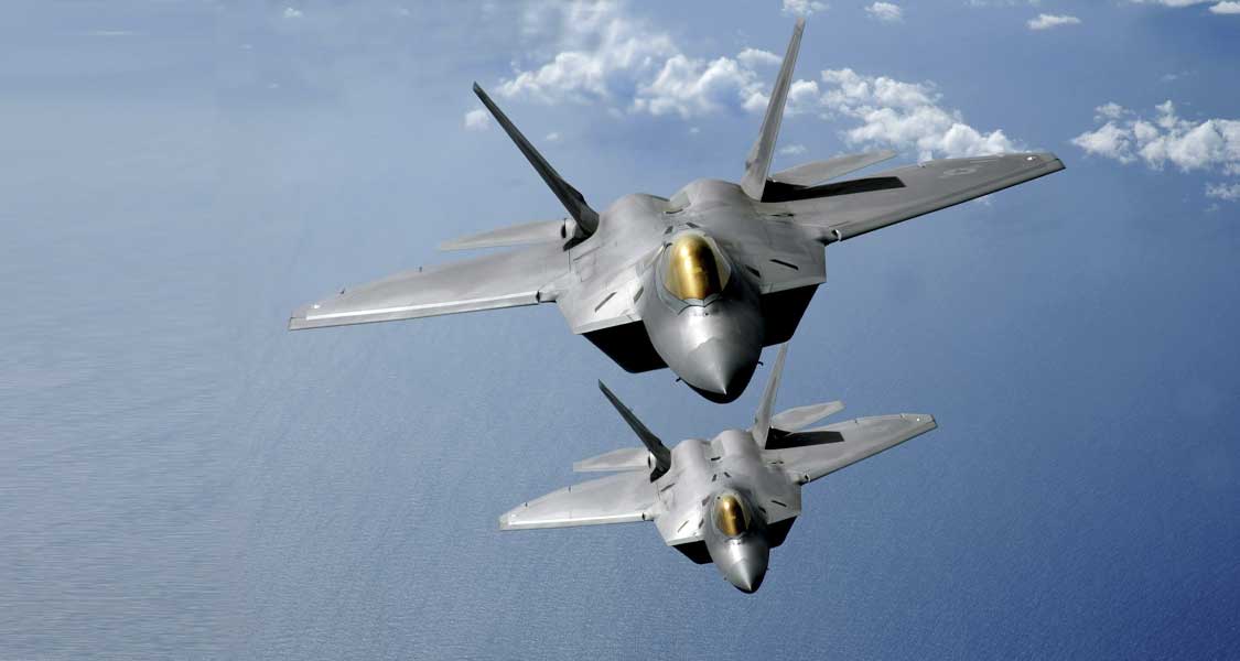 Two F-22 Raptors fly over the Pacific Ocean during a theater security mission as part of a deployment to Andersen Air Force Base, Guam