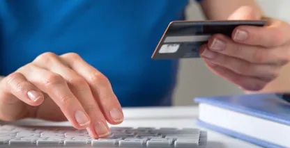 A hand holding a credit card